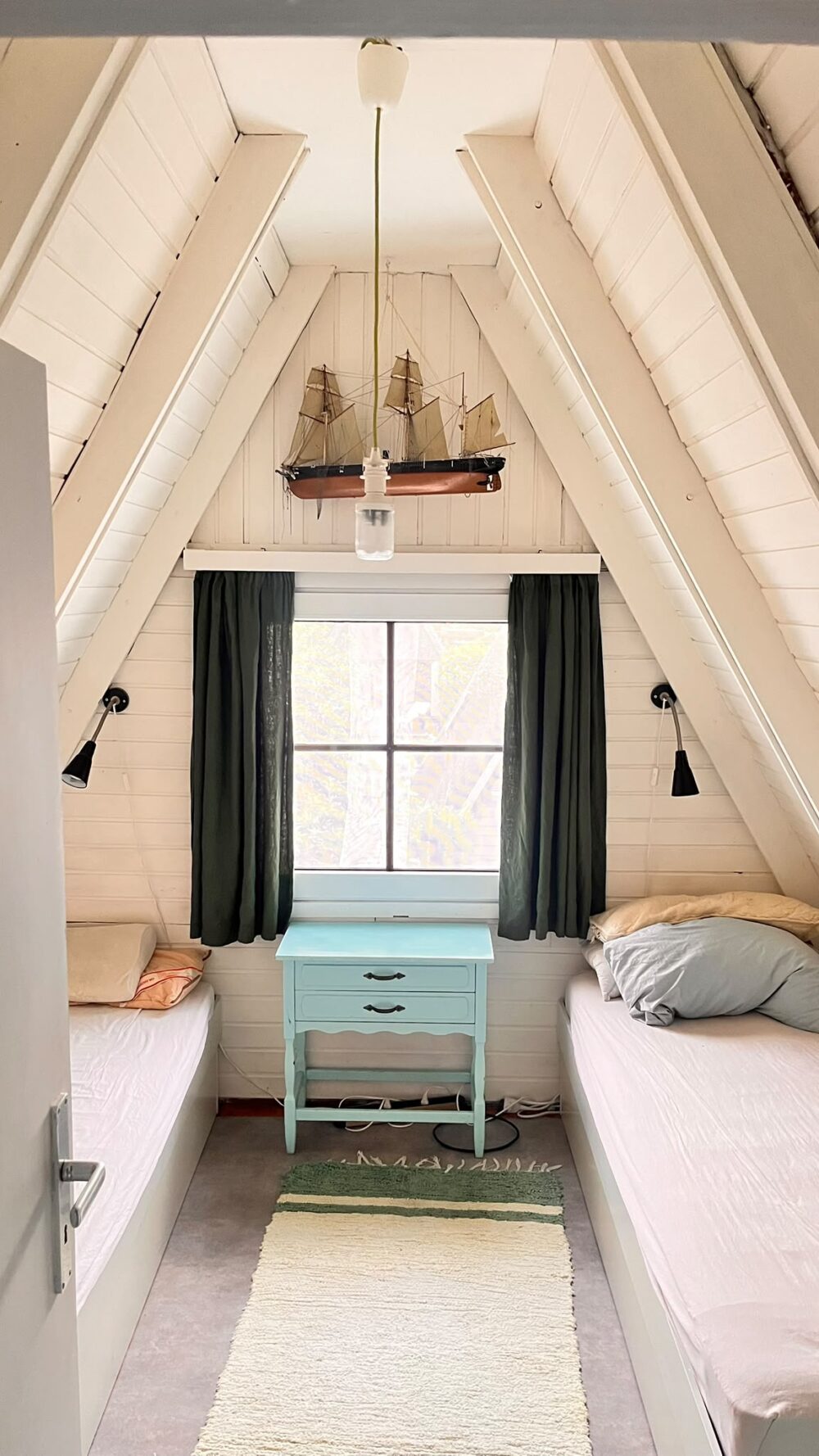 Schlafzimmer unter der Dachschräge mit Schiffsmodell-Leuchte