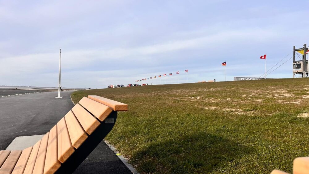 Promenade am Deich in Friedrichskoog-Spitze mit Bank, wehenden Flaggen und Strandkörben